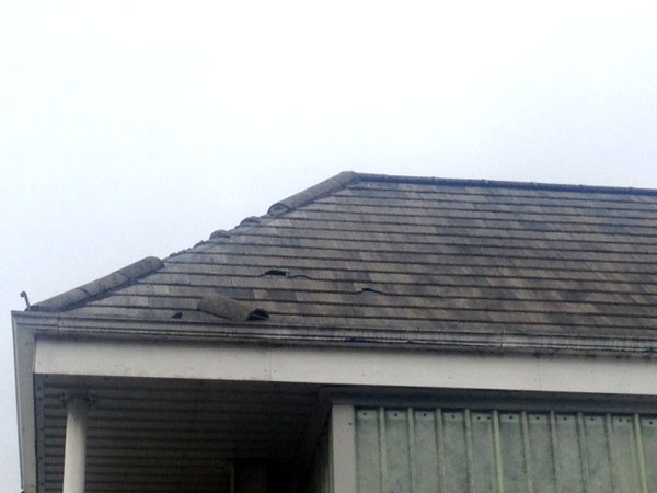 Showing corner of damaged tiled roof